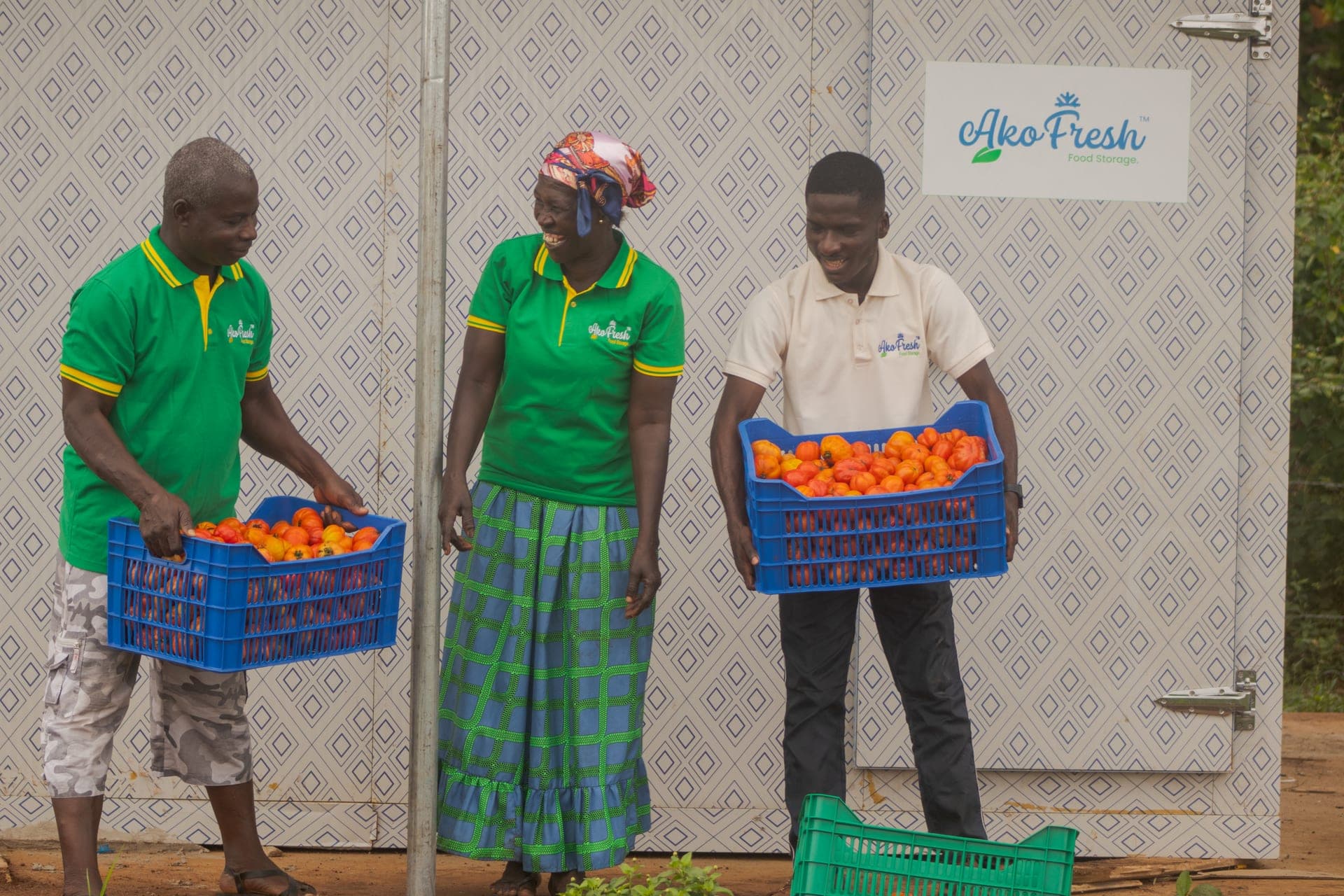 AkoFresh colleagues carrying crates of tomatoes at a solar-powered cold storage hub.