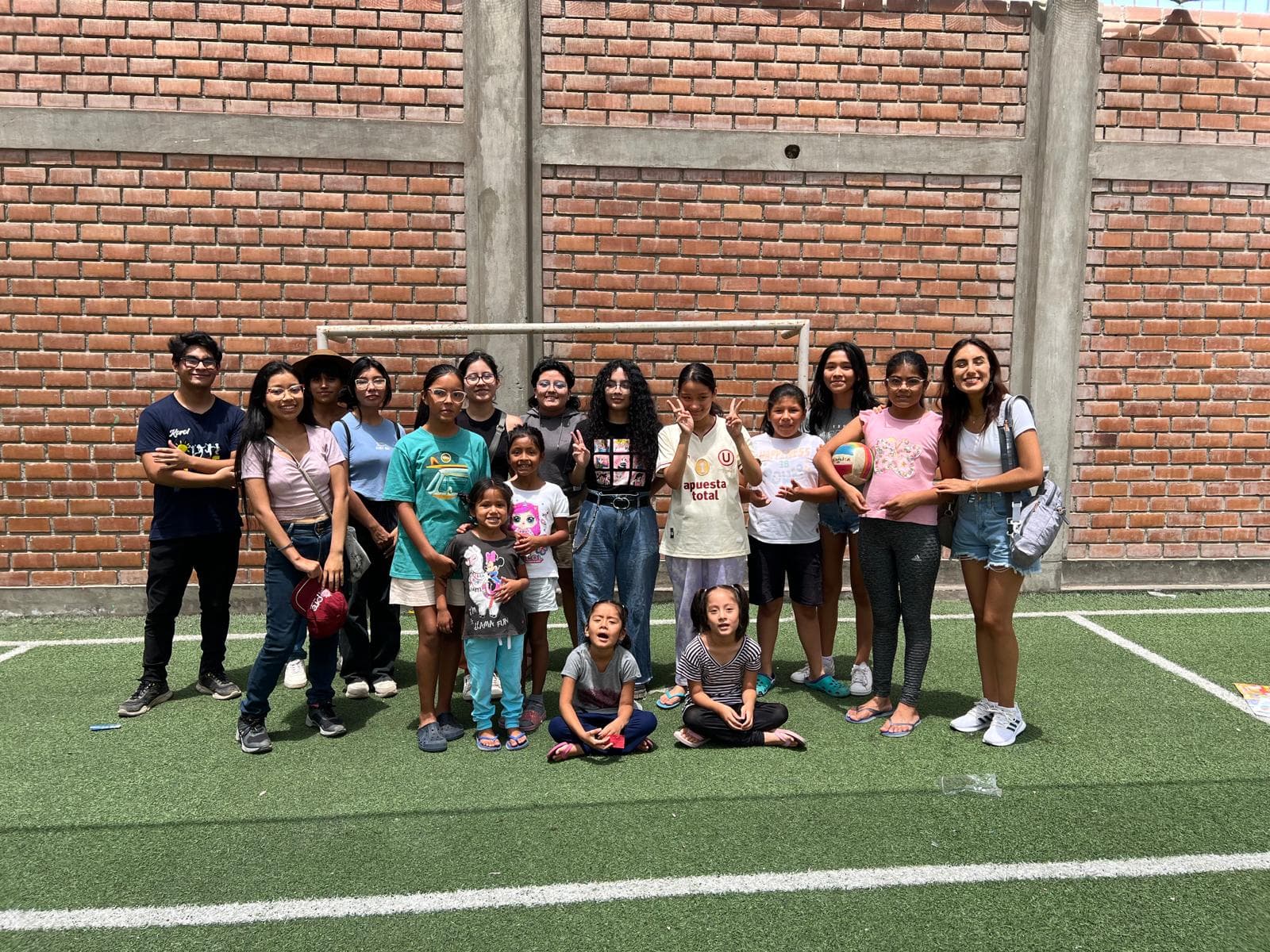 Youth and Kectil community members gathered outdoors on turf.